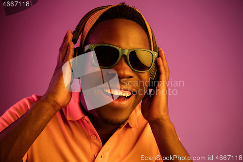 Image of The young handsome hipster man listening music with headphones