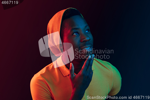 Image of Portrait of a happy young african american man smiling on black neon background