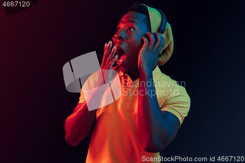 Image of The young handsome hipster man listening music with headphones