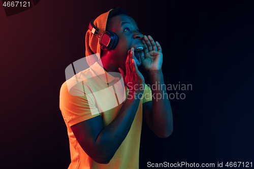 Image of The young handsome hipster man listening music with headphones