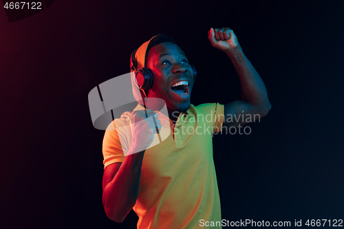 Image of The young handsome hipster man listening music with headphones