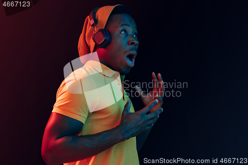 Image of The young handsome hipster man listening music with headphones