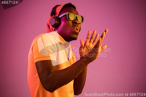 Image of The young handsome hipster man listening music with headphones