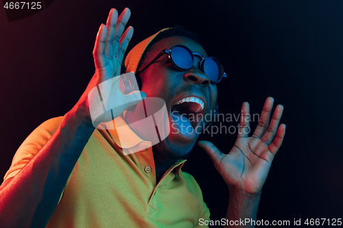 Image of The young handsome hipster man listening music with headphones