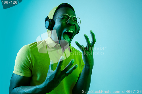 Image of The young handsome hipster man listening music with headphones