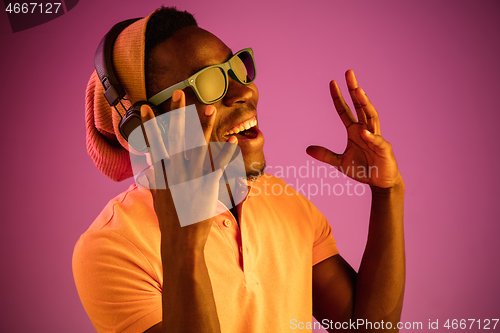 Image of The young handsome hipster man listening music with headphones