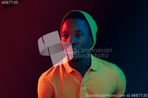 Image of Portrait of a happy young african american man smiling on black neon background