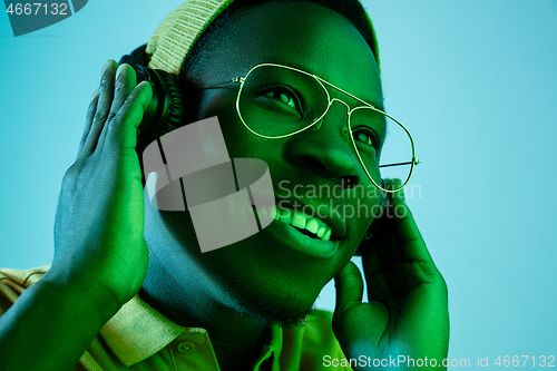 Image of The young handsome hipster man listening music with headphones