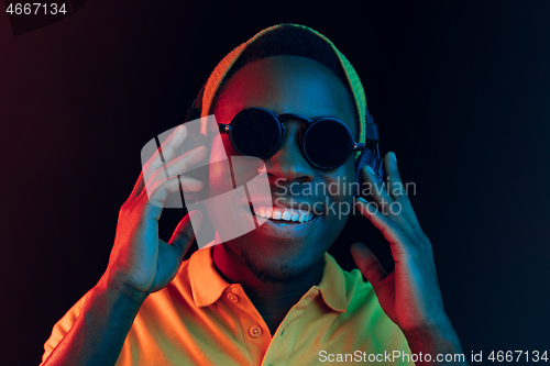 Image of The young handsome hipster man listening music with headphones