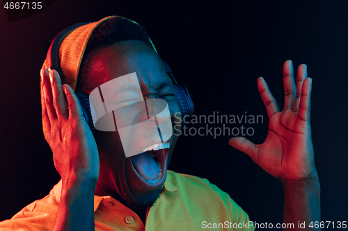 Image of The young handsome hipster man listening music with headphones