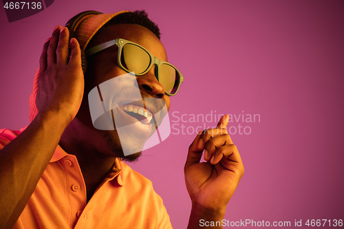 Image of The young handsome hipster man listening music with headphones