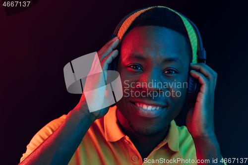 Image of The young handsome hipster man listening music with headphones