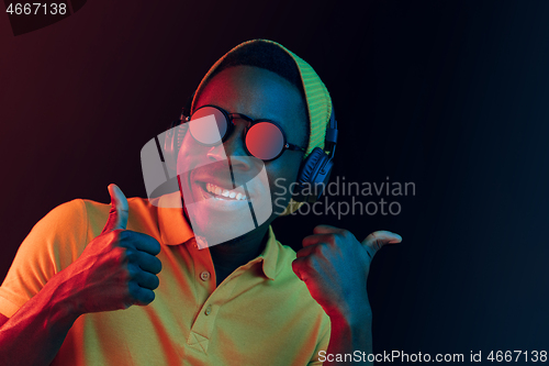 Image of The young handsome hipster man listening music with headphones