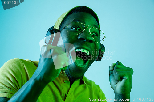 Image of The young handsome hipster man listening music with headphones