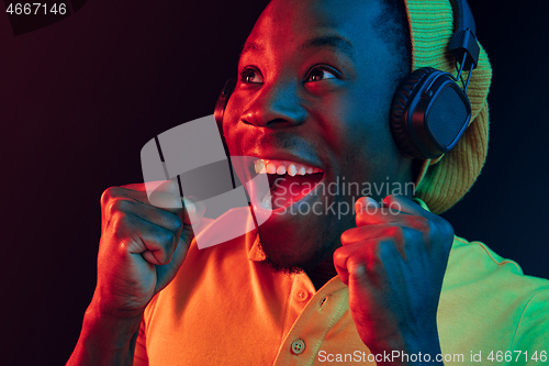 Image of The young handsome hipster man listening music with headphones