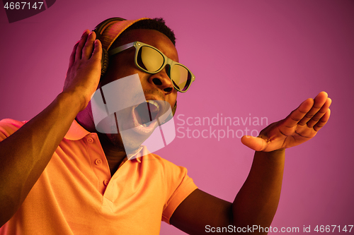 Image of The young handsome hipster man listening music with headphones