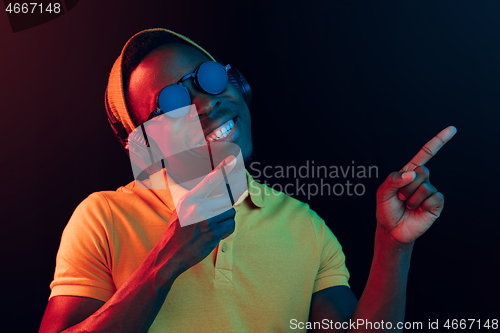 Image of The young handsome hipster man listening music with headphones