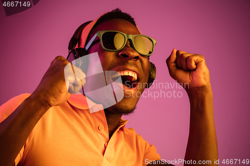 Image of The young handsome hipster man listening music with headphones