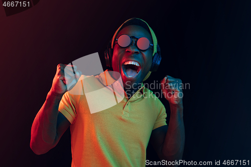 Image of The young handsome hipster man listening music with headphones