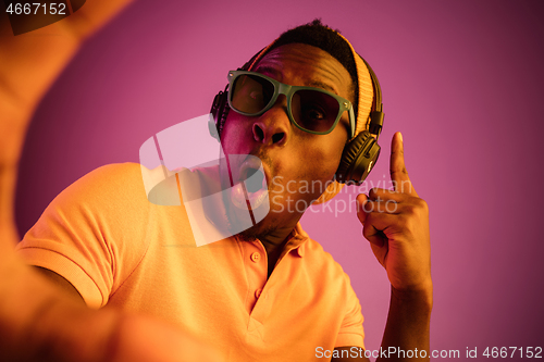 Image of The young handsome hipster man listening music with headphones