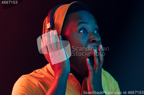 Image of The young handsome hipster man listening music with headphones