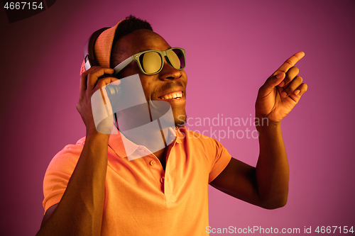 Image of The young handsome hipster man listening music with headphones