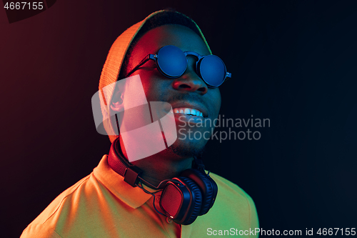 Image of The young handsome hipster man listening music with headphones