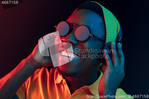 Image of The young handsome hipster man listening music with headphones