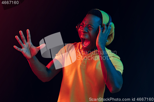 Image of The young handsome hipster man listening music with headphones