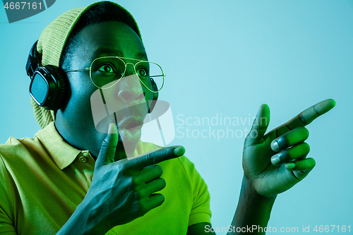 Image of The young handsome hipster man listening music with headphones