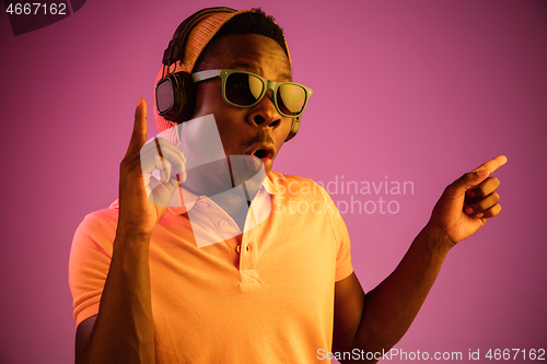 Image of The young handsome hipster man listening music with headphones