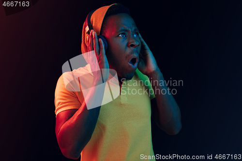 Image of The young handsome hipster man listening music with headphones