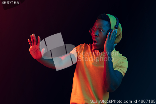 Image of The young handsome hipster man listening music with headphones