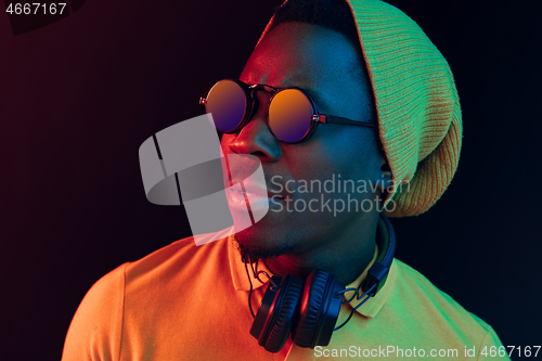 Image of The young handsome hipster man listening music with headphones