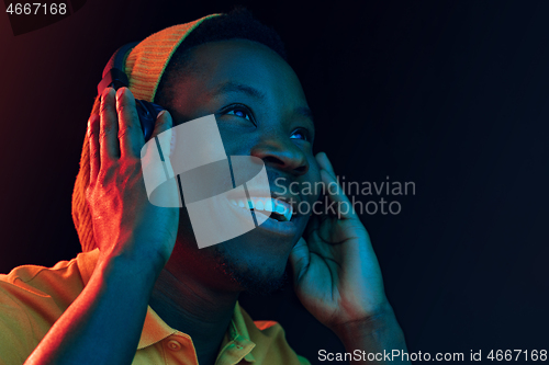 Image of The young handsome hipster man listening music with headphones