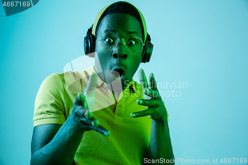 Image of The young handsome hipster man listening music with headphones