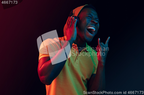 Image of The young handsome hipster man listening music with headphones