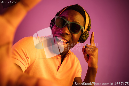 Image of The young handsome hipster man listening music with headphones