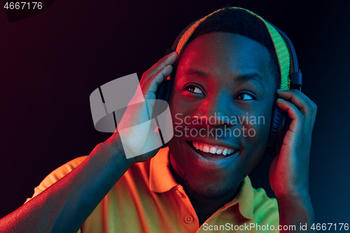 Image of The young handsome hipster man listening music with headphones