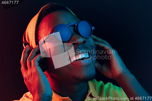 Image of The young handsome hipster man listening music with headphones