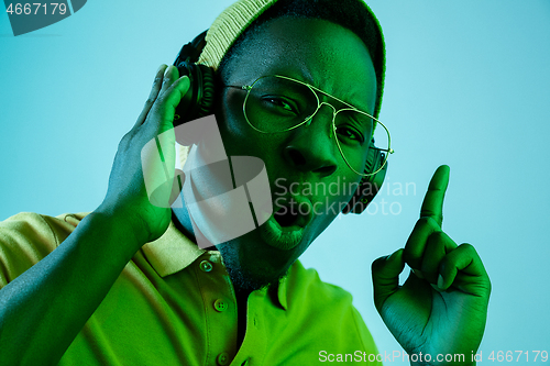 Image of The young handsome hipster man listening music with headphones