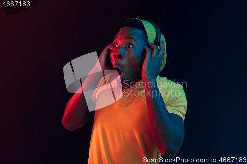 Image of The young handsome hipster man listening music with headphones