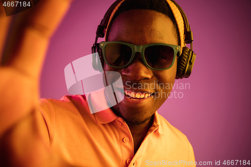 Image of The young handsome hipster man listening music with headphones