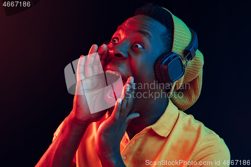 Image of The young handsome hipster man listening music with headphones