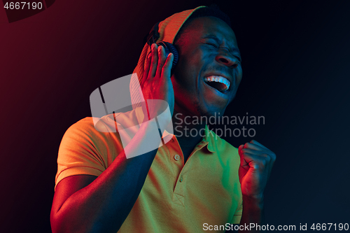 Image of The young handsome hipster man listening music with headphones