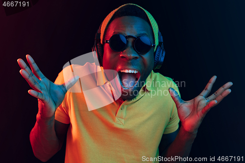 Image of The young handsome hipster man listening music with headphones