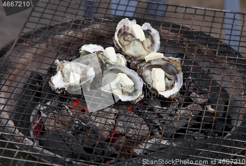 Image of Shellfish frying on a street oven