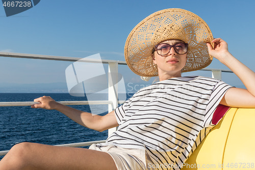 Image of Beautiful, romantic blonde woman taking selfie self portrait photo on summer vacations traveling by cruse ship ferry boat.