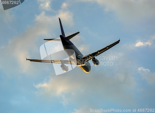 Image of Airplane in clouds at sunset