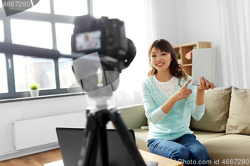 Image of asian female blogger making video review of book